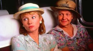duas mulheres sentadas em cena de filme #paratodosverem