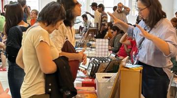 pessoas olhando produtos em feira #paratodosverem