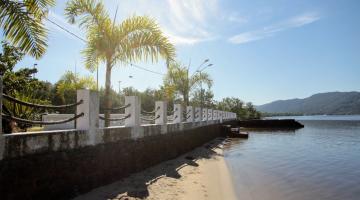 o mar, uma faixa de areia e um muro. #paratodosverem