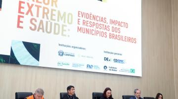 pessoas sentadas em mesa de painel #paratodosverem