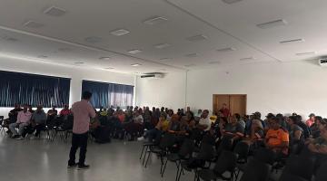 homem fala a pessoas sentadas em frente #paratodosverem