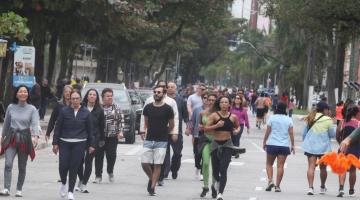 pessoas caminhando e correndo na praia #paratodosverem 