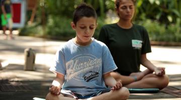 Crianças meditam em meio ao verde do Orquidário