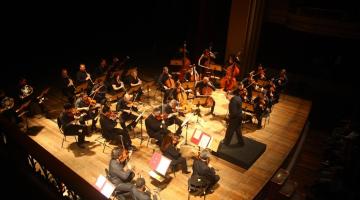 orquestra se apresentando em cima de palco #paratodosverem