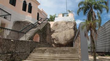 o outeiro de santa catarina, com escada de acesso em primeiro plano. Grande pedra ao fundo e construção à esquerda. #paratodosverem
