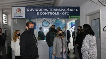 Cabine da ouvidoria com várias pessoas na frente. #paratodosverem