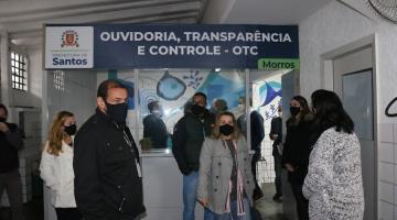 Cabine da ouvidoria com várias pessoas na frente. #paratodosverem