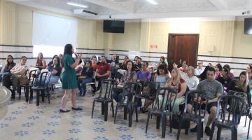 pessoa fala em pé e outras estão sentadas
