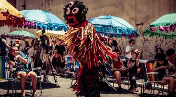 boneco grande perto de pessoas #paratodosverem