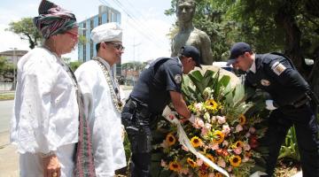 Deposição de flores no busto de Zumbi por dois guardas municipais. #paratodosverem