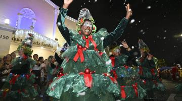 mulher desfila fantasiada de árvore de natal e acena para o público. #paratodos