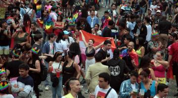 parada lgbt+ em rua, com pessoas fantasiadas se divertindo. #paratodosverem 