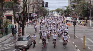 Dezenas de ciclistas e bicicletas passam por avenida. #paratodosverem