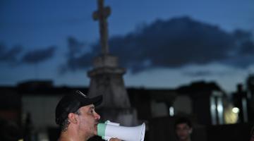 homem com megafone em cemitério à noite. #paratodosverem