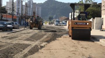 máquina compactadora percorre rua coberta de areia. #paratodosverem