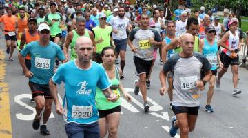 Atletas correm em avenida durante competição. #paratodosverem