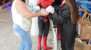 Mulher entrega garrafas de água para Homem Aranha e personagem de Harry Potter.