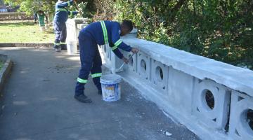 dois homens pintam mureta. #paratodosverem 