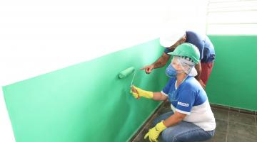 mulher pinta parede observada por professor #paratodosverem 