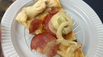 pedaço de pizza em um prato plástico #paratodosverem