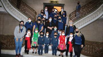 Alunos, autoridades e educadores posam para foto na escadaria do saguão da prefeitura. #paratodosverem