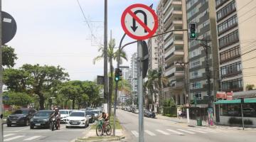 EM PRIMEIRO PLANO ESTÁ UMA PLACA PROIBINDO CONVERSÃO, COLOCADA EM CANTEIRO CENTRAL DA ORLA. áRVORES ESTÃO DO LADO ESQUERDO DA IMAGEM, E PRÉDIOS, À DIREITA. #PARATODOSVEREM