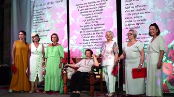 poetas estão em pé à frente de grandes banners com poesias impressas. #paratodosverem