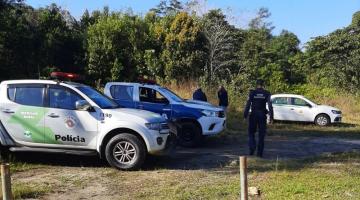 em área de mata, viaturas da guarda, da policia, e agentes #paratodosverem