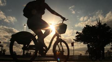 pessoa andando de bicicleta ao pôr do sol #paratodosverem