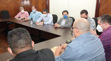 Representantes da Autoridade Portuária, de trabalhadores e da Prefeitura reunidos em torno de uma grande mesa. Eles conversam. #paratodosverem