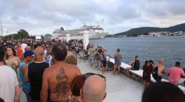 Calçadão de frente para o mar. navio de cruzeiro ao fundo e grande público e primeiro plano. #Pracegover