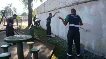 homens pintam muro em praça. #paratodosverem