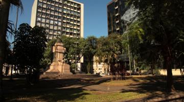 vista geral da praça barão do rio branco, com monumento ao centro e vegetação nas 