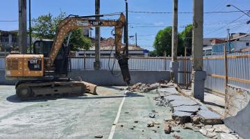 escavadeira quebra piso antigo Ela está dentro de área tapumada