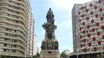 o monumento dos andradas no centro da  praça da independência, entre dois prédios. #paratodosverem