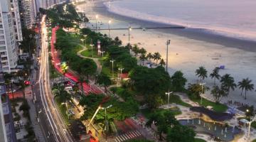 Foto área da praia de Santos aparecendo mar, faixa de areia, jardins e avenida #paratodosverem