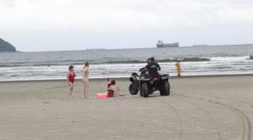 Guardas municipais abordam banhistas em faixa de areia. #paratodosverem