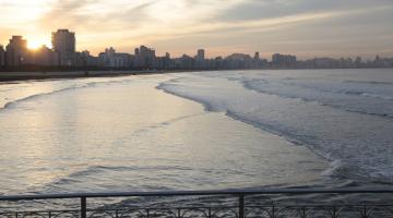 Vista geral do mar em Santos. Em primeiro plano, na parte de baixo, um pedaço da mureta em aço no canal junto ao mar. #Paratodosverem