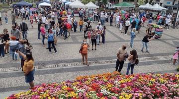 Várias pessoas na praça e muitas flores #paratodosverem