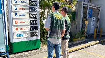 fiscais do procon observam placa com preços de combustíveis. #paratodosverem