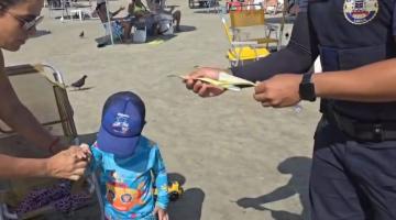 guarda coloca pulseira em criança #paratodosverem