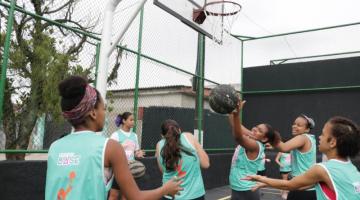 Meninas jogam basquete na quadra reformada. #pracegover