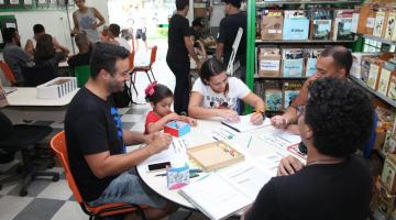 pessoas em mesa na gibiteca #paratodosverem