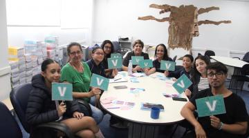 alunos mostram cartazes com a letra V #paratodosverem