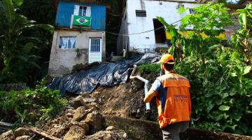 Técnico da defesa civil observa moradia em morro #pracegover