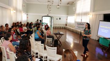 professora fala enquanto alunos do curso acompanham sentados #pracegover 