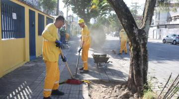 homens varrem rua após raspação de calçadas. #paratodosverem