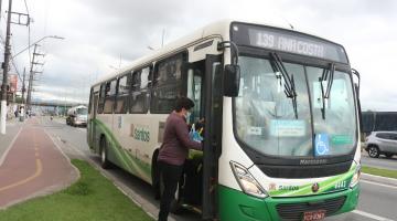 ônibus parada em via com pessoa subindo pela porta da frente. #paratodosverem