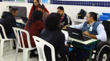 pessoas atendidas por servidores em computadores #pracegover 