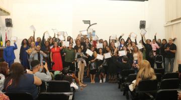 formandos posam para fotos exibindo certificados. #paratodosverem